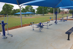 Outdoor fitness amenities like ab benches in a pavilion.