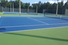 A blue outdoor tennis court at a park.